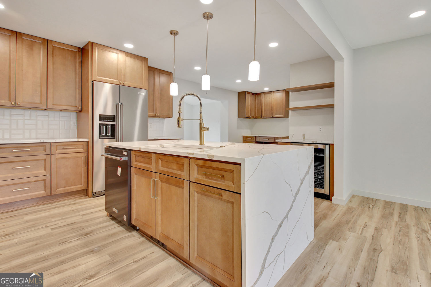 a kitchen with a sink a counter top space stainless steel appliances and cabinets