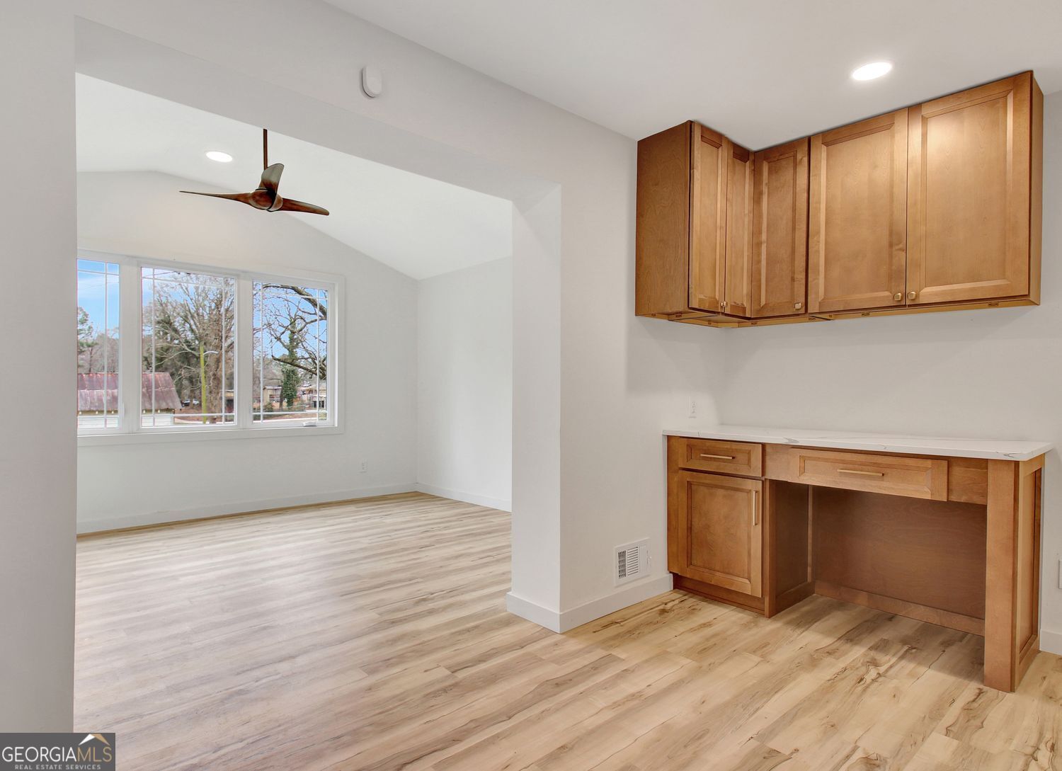 183 Pine Street Northeast Fairburn, GA 30213 - Photo 23 of 68 an empty room with wooden floor cabinet and a view of kitchen