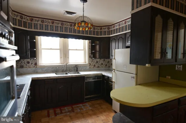 a kitchen with granite countertop a sink stainless steel appliances and a window