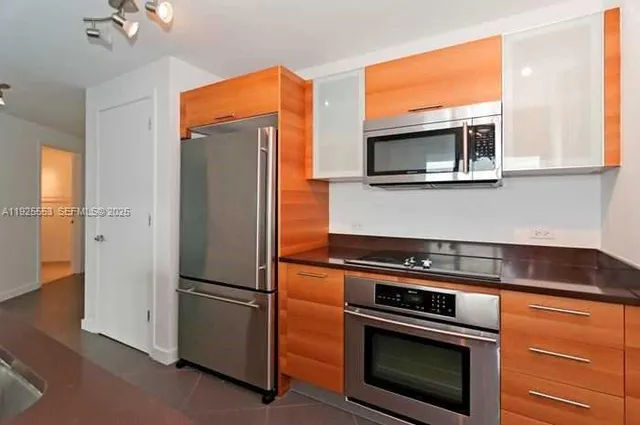 a kitchen with stainless steel appliances granite countertop a refrigerator and a microwave