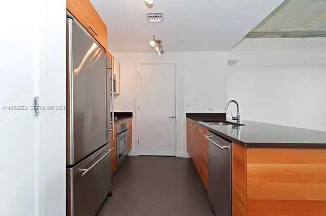a kitchen with stainless steel appliances granite countertop a refrigerator and a sink