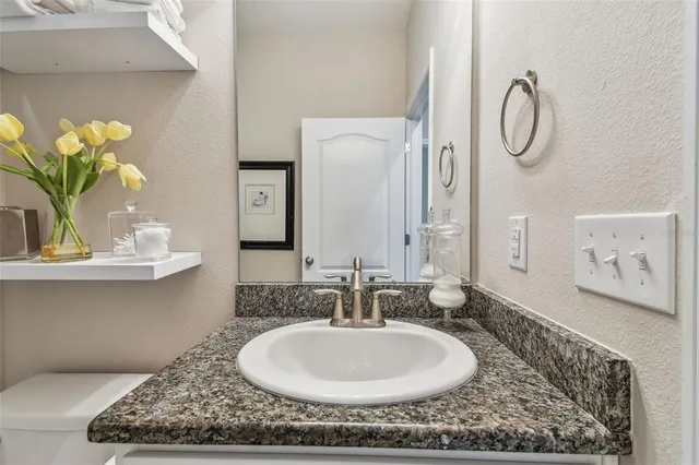 a bathroom with a granite countertop sink and a mirror