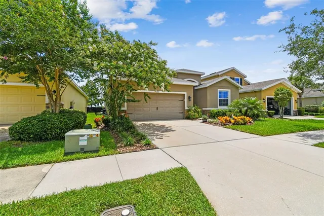 a front view of a house with a yard and potted plants
