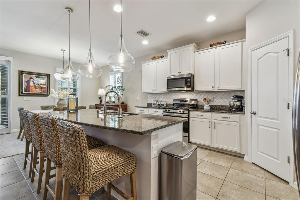 6467 Seasound Drive Apollo Beach, FL 33572 - Photo 23 of 81 a kitchen with kitchen island granite countertop a sink a counter top space appliances and cabinets