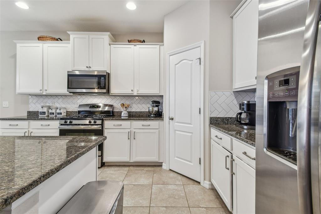 6467 Seasound Drive Apollo Beach, FL 33572 - Photo 24 of 81 a kitchen with stainless steel appliances granite countertop a refrigerator and a stove top oven