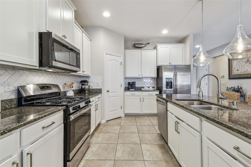 6467 Seasound Drive Apollo Beach, FL 33572 - Photo 28 of 81 a kitchen with stainless steel appliances granite countertop a sink a stove and cabinets