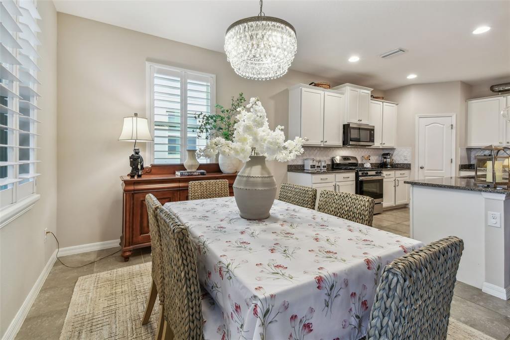 6467 Seasound Drive Apollo Beach, FL 33572 - Photo 34 of 81 a view of a dining room with furniture and a chandelier