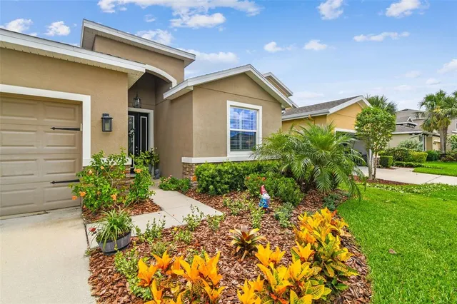 a front view of a house with a yard and potted plants