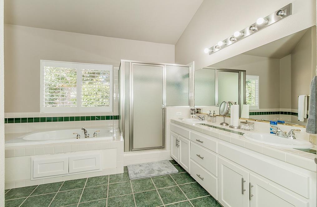 2074 East Revere Road Fresno, CA 93720 - Photo 17 of 39 a spacious bathroom with a double vanity sink a mirror and a bathtub