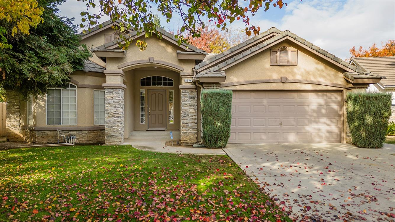 2074 East Revere Road Fresno, CA 93720 - Photo 2 of 39 a front view of a house with a yard