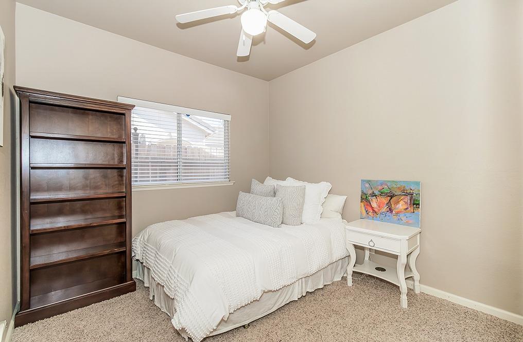 2074 East Revere Road Fresno, CA 93720 - Photo 23 of 39 a bedroom with a bed and a chandelier