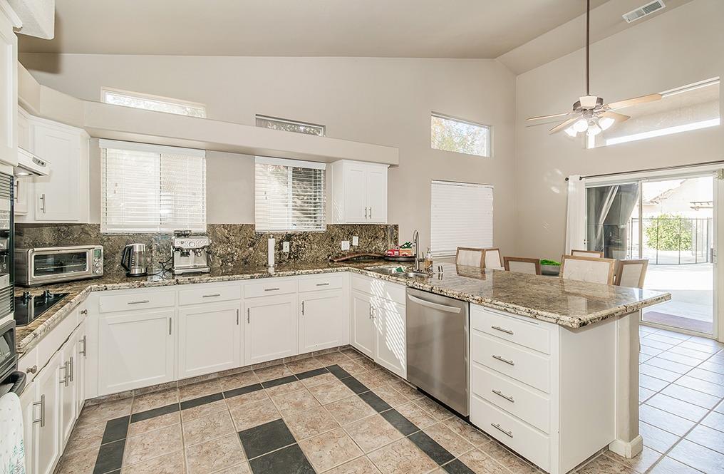 2074 East Revere Road Fresno, CA 93720 - Photo 9 of 39 a kitchen with granite countertop cabinets stainless steel appliances a sink and a window