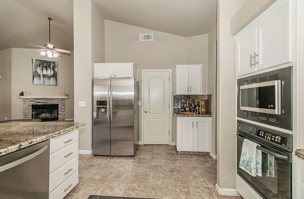 2074 East Revere Road Fresno, CA 93720 - Photo 10 of 39 a kitchen with stainless steel appliances granite countertop a refrigerator and a stove top oven
