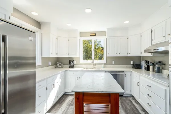 a kitchen with a sink a window and stainless steel appliances