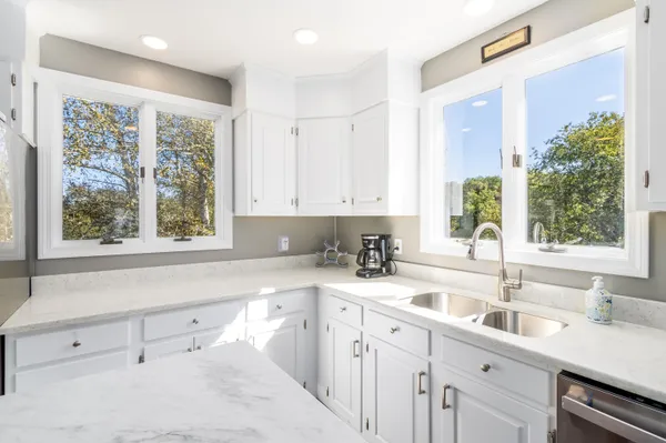 a kitchen with a sink a window and cabinets