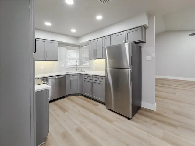 a kitchen with kitchen island a refrigerator sink and cabinets