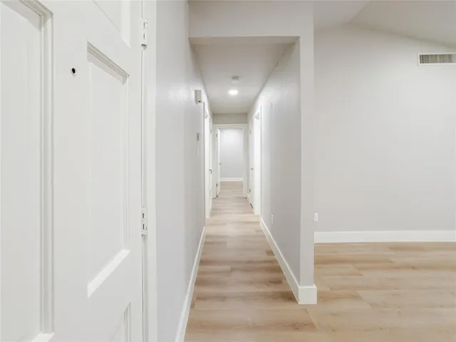 a view of a hallway with wooden floor