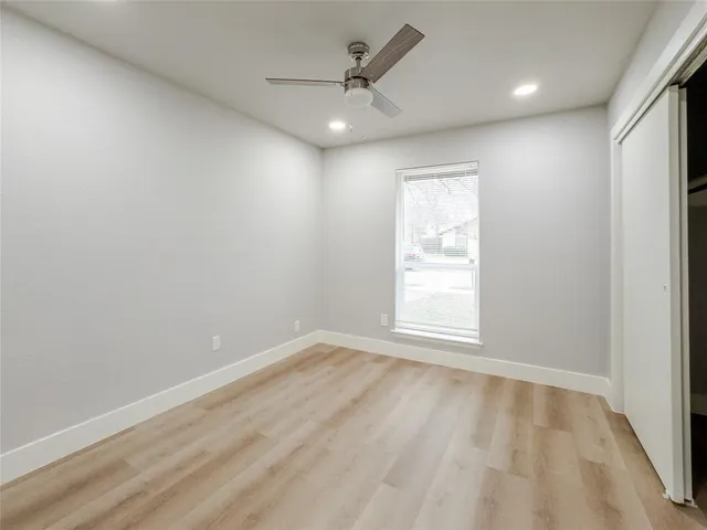 an empty room with a window and a fan