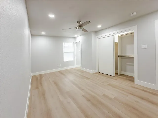 an empty room with windows and cabinet