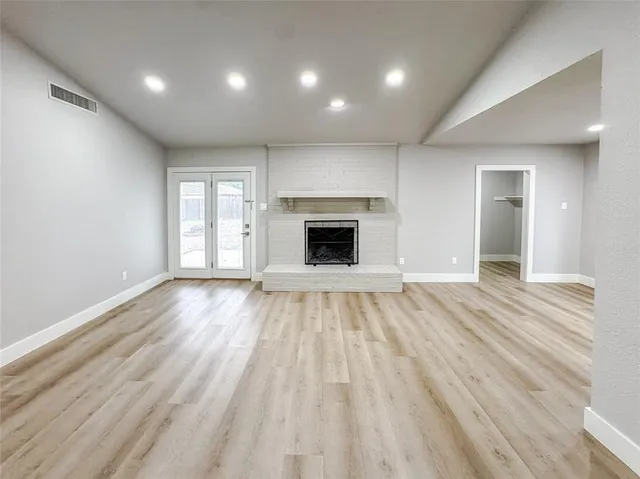 an empty room with wooden floor and fireplace