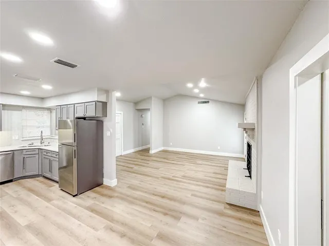 a view of a kitchen with a refrigerator and a sink
