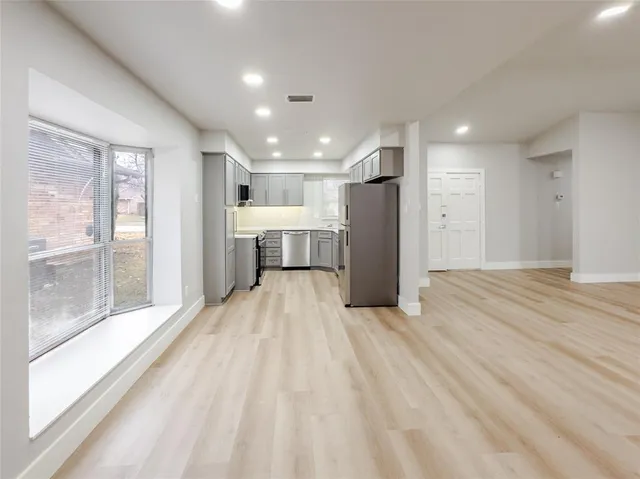 a view of empty room with wooden floor and window