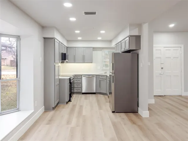 a kitchen with refrigerator and cabinets