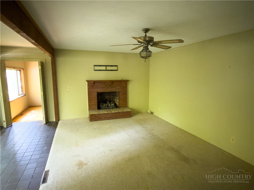 1205 Bamboo Road Boone, NC 28607 - Photo 17 of 17 an empty room with a fireplace and wooden floor