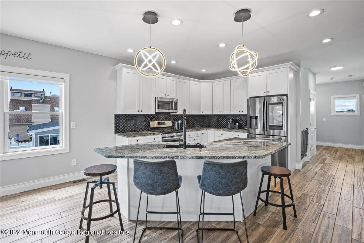 35 Channel Road Toms River, NJ 08753 - Photo 11 of 41 a kitchen with kitchen island granite countertop a dining table and chairs in it