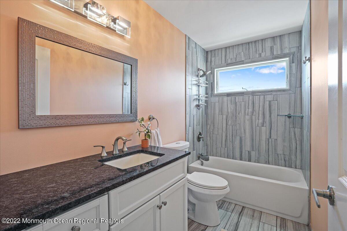 35 Channel Road Toms River, NJ 08753 - Photo 23 of 41 a bathroom with a granite countertop toilet a sink and a mirror