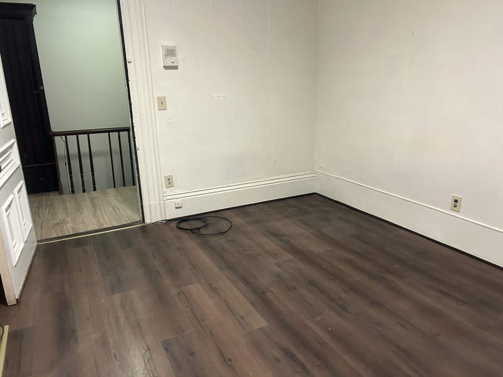 14 Monument Square, Unit 2 Boston, MA 02129 - Photo 4 of 5 an empty room with wooden floor and entrance