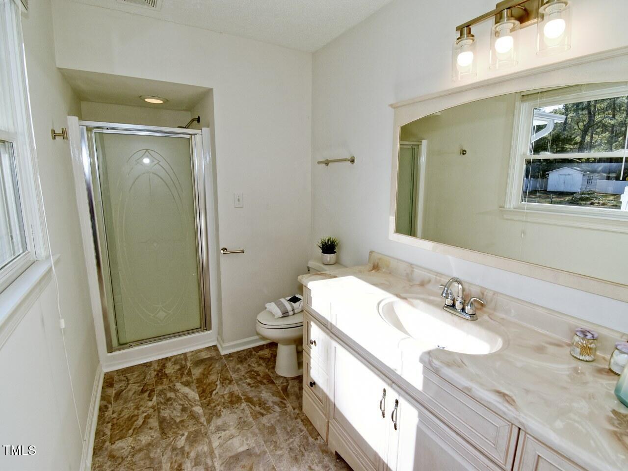 3217 Banks Road Raleigh, NC 27603 - Photo 17 of 29 a spacious bathroom with a granite countertop sink and a mirror