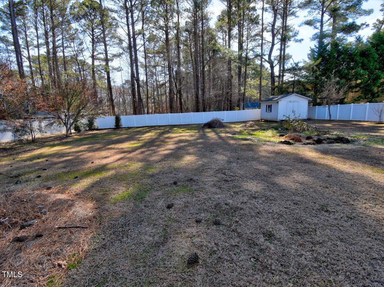 3217 Banks Road Raleigh, NC 27603 - Photo 26 of 29 a view of a backyard with large trees and wooden fence