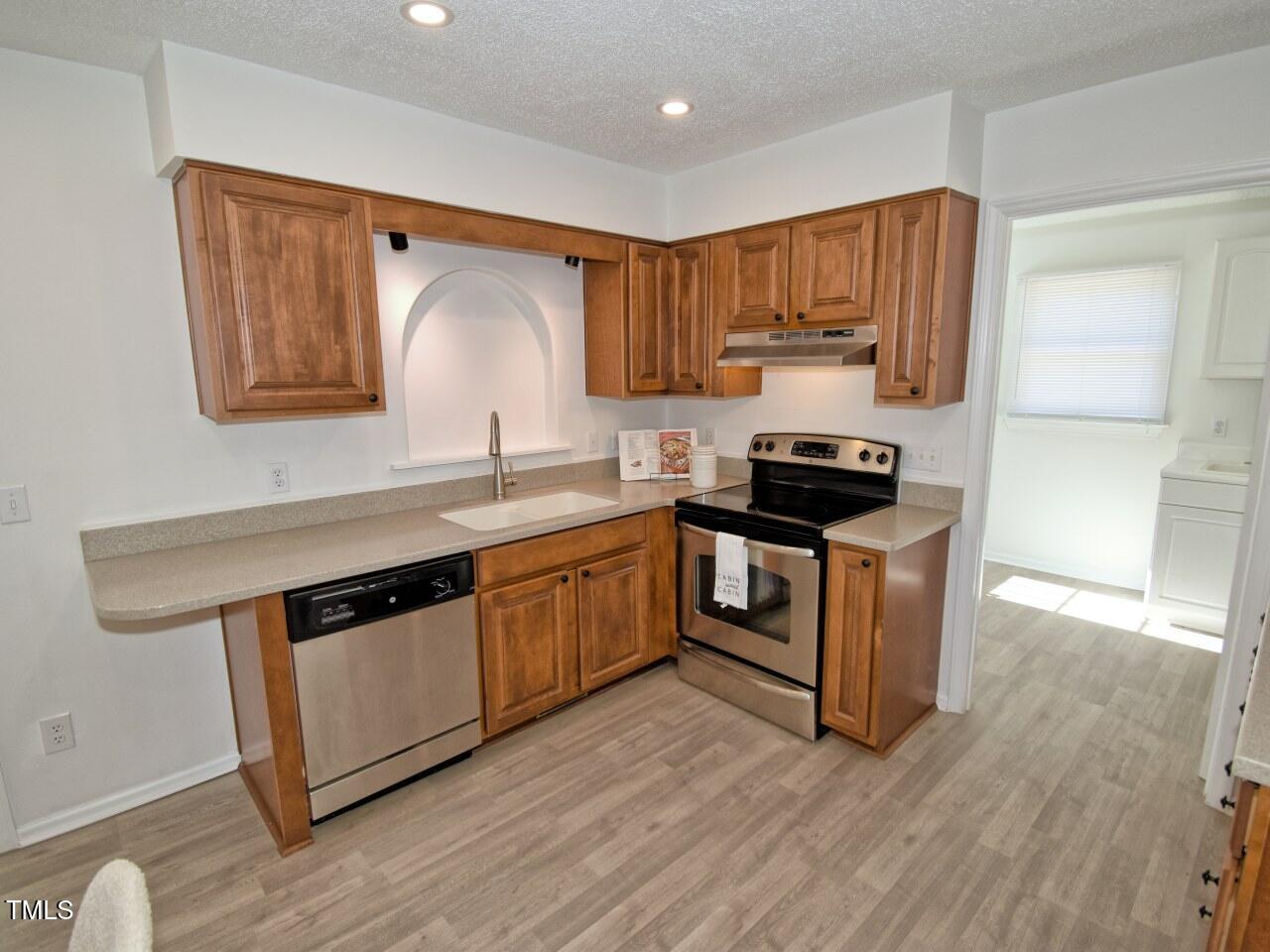 3217 Banks Road Raleigh, NC 27603 - Photo 8 of 29 a kitchen with granite countertop wooden cabinets and a stove top oven