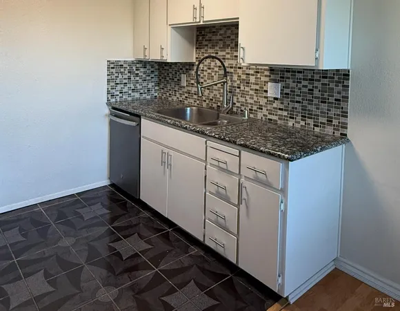 a kitchen with granite countertop a sink and a stove