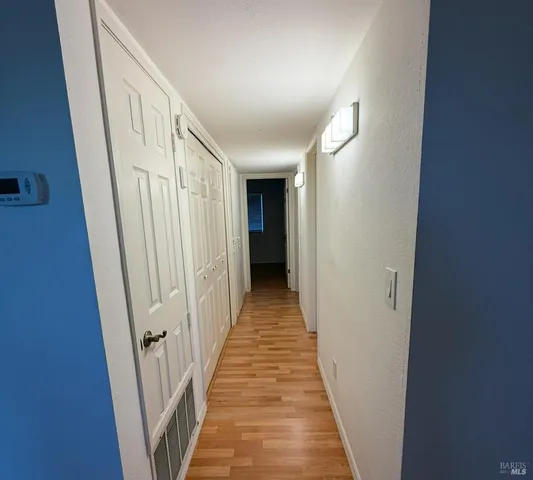 a view of a hallway with wooden floor and staircase
