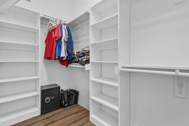 a view of walk in closet with clothes and shoes