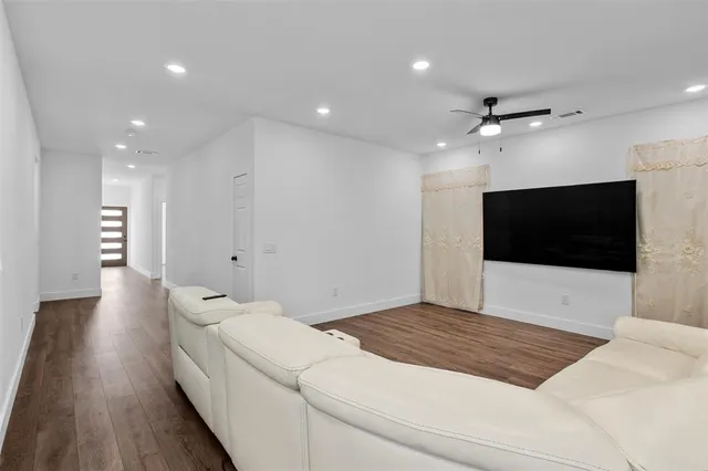 a living room with a bed furniture and a flat screen tv