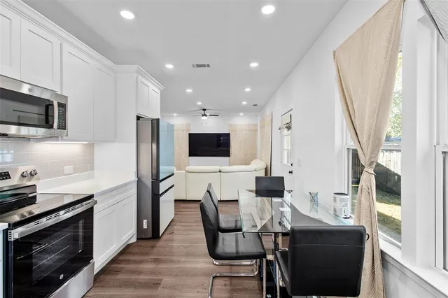 a kitchen with stainless steel appliances kitchen island granite countertop a stove a sink a microwave a refrigerator and cabinets