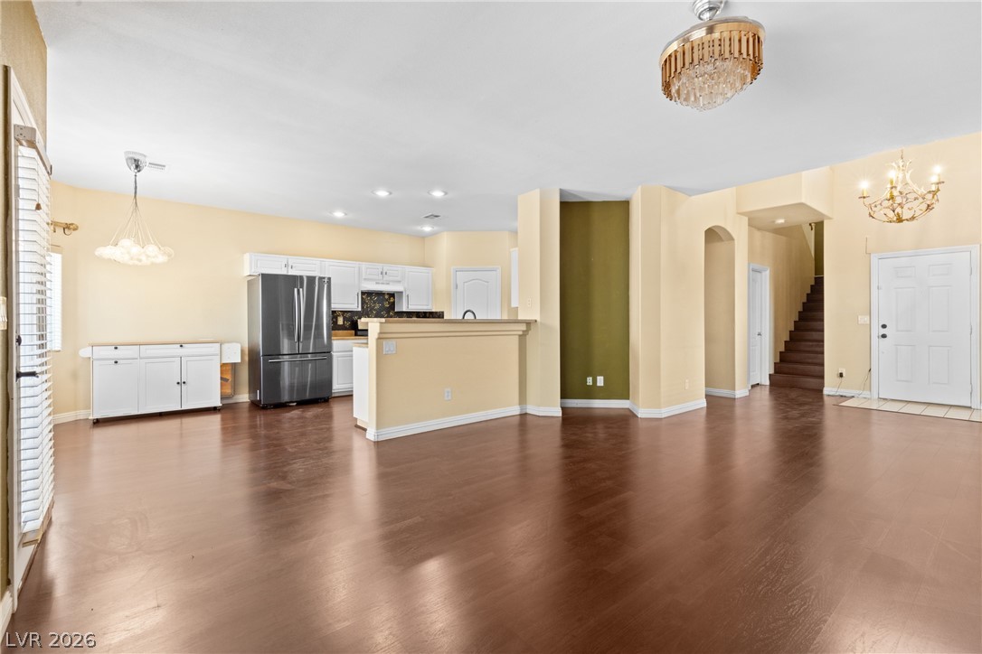 8934 Deep Ridge Court Las Vegas, NV 89178 - Photo 8 of 47 Rich hardwood flooring extends through this open-concept main level, connecting kitchen, living, and entry spaces.