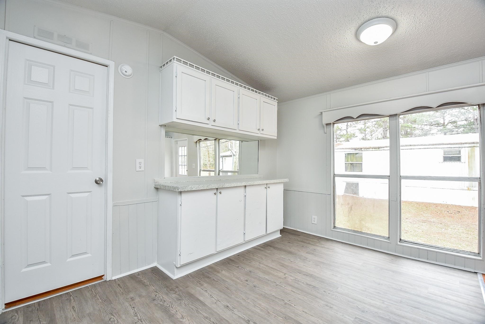 12842 Roy Harris Loop Conroe, TX 77306 - Photo 24 of 36 an empty room with wooden floor and windows