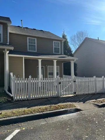 a view of a house with a small yard and wooden fence