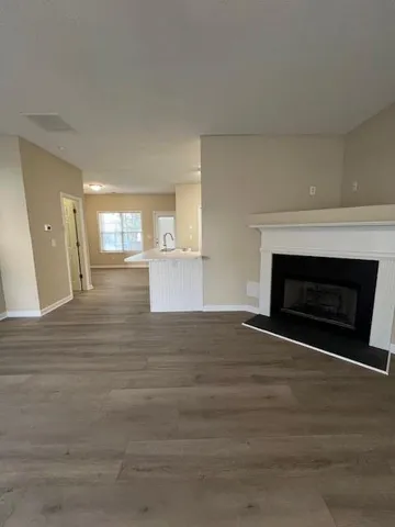 a view of empty room with wooden floor and fireplace