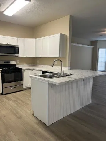 a kitchen with a sink a stove and cabinets