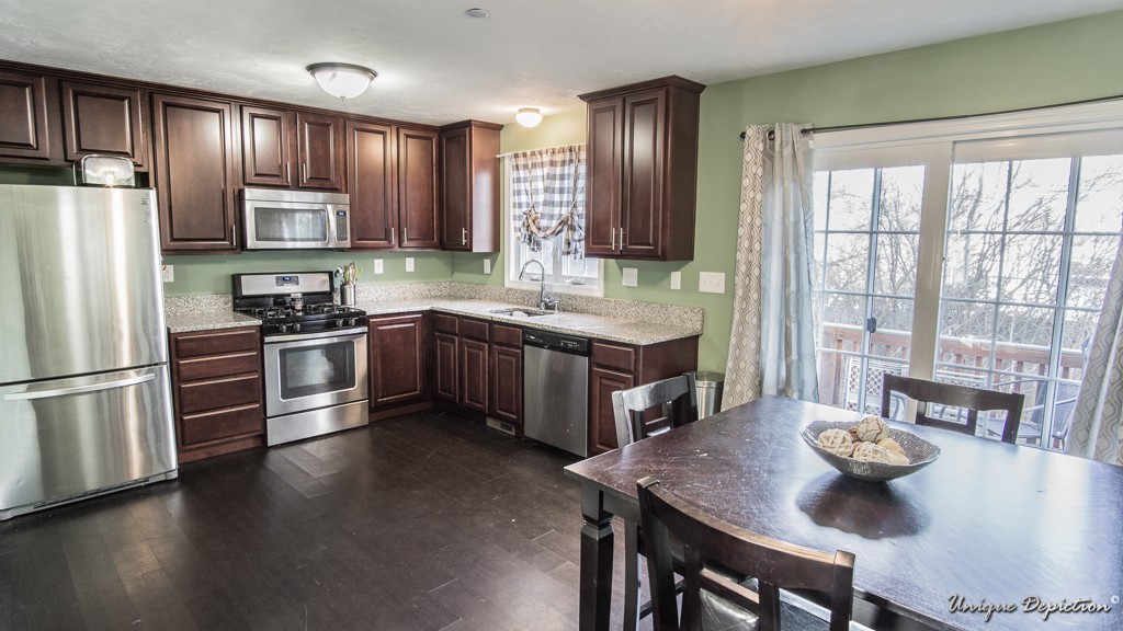 41 Boston Road, Unit 451 Billerica, MA 01862 - Photo 5 of 20 a kitchen with stainless steel appliances granite countertop a stove a refrigerator a sink a dining table and chairs