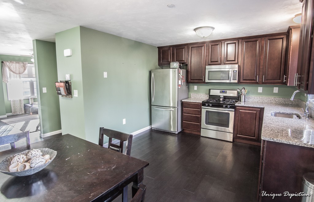 41 Boston Road, Unit 451 Billerica, MA 01862 - Photo 6 of 20 a kitchen with stainless steel appliances wooden floor dining table and chairs