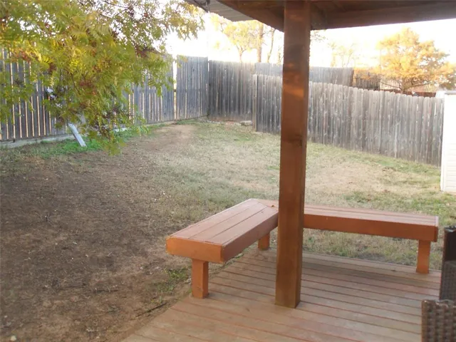 a view of a yard with wooden fence and floor