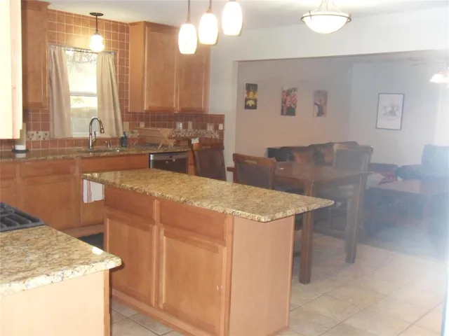 a kitchen with stainless steel appliances granite countertop a sink a stove and a refrigerator