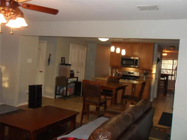 a living room with furniture a flat screen tv and kitchen view