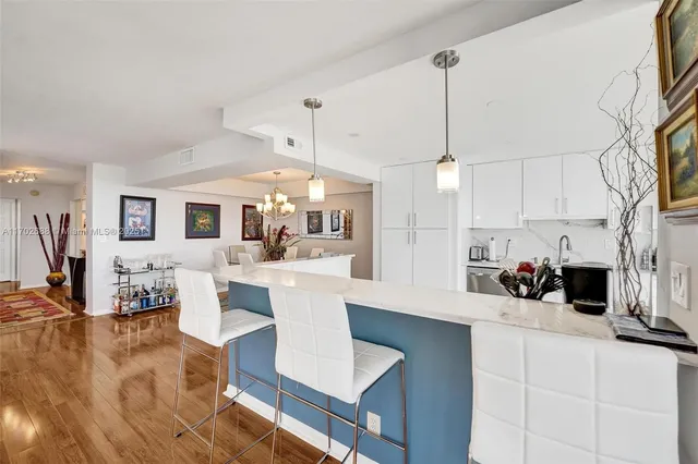 a kitchen with stainless steel appliances granite countertop a refrigerator stove and white cabinets